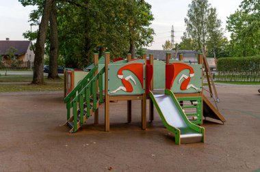 Çocuk parkında tırmanış yapıları ve güneşli bir öğleden sonra kaydırak var..
