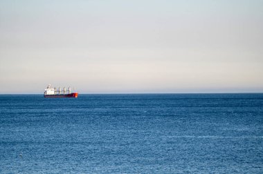 Bir kargo gemisi açık bir günde durgun bir denizde sürekli hareket eder..
