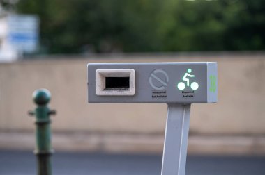 Bisiklet, güneşli bir günde bir bisiklet paylaşım istasyonuna park edilmiş.