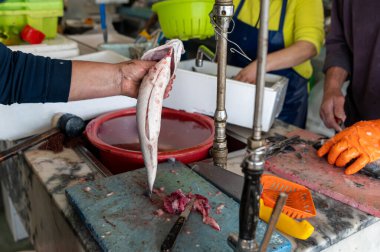 Kalabalık bir şehrin sabahın erken saatlerinde yerel bir markette taze balık hazırlamak.