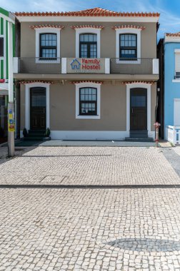 Costa Nova, Portekiz - 11 Eylül 2024: Güneşli bir sahil kasabasındaki bir parke taşı caddesinde barınak sağlayan bir aile pansiyonu.