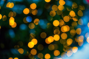 Açık çelenkle süslenmiş Noel ağacı. Bokeh ışıkları olan bir tatil geçmişi. Boşluğu kopyala