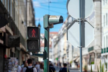 A red pedestrian light encourages safe crossing in a bustling urban environment. clipart