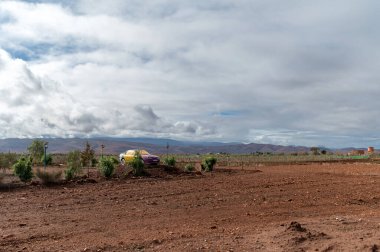 Marakeş, Fas - 19 Şubat 2025: canlı sarı bir araba Marakeş, Fas yakınlarındaki toprak arazide göze çarpıyor. Reklamcılık