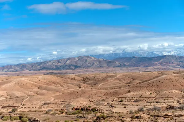 Fas çölünde Agafay 'ın engin manzarası kurak araziyi ve uzak dağları gösteriyor.
