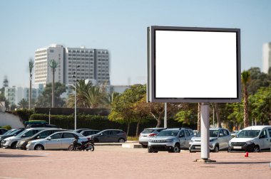 Fas 'ta arabalarla çevrili bir otoparkta büyük boş bir ilan panosu sergileniyor..