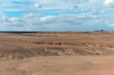 Fas 'taki Agafay Çölü' nde kayalık arazi ve çarpıcı dağ manzaraları vardır..