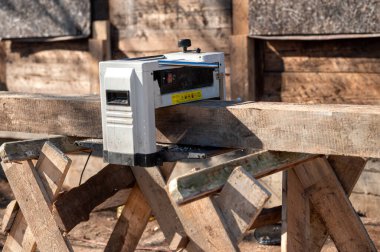 Alet, açık mavi gökyüzünün altında, dışarıda çalışan ahşap bir kalasla pürüzsüzleştiriyor.