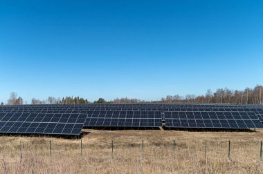 Güneş panelleri öğleden sonra açık mavi gökyüzü ile karaya kurulmuş..