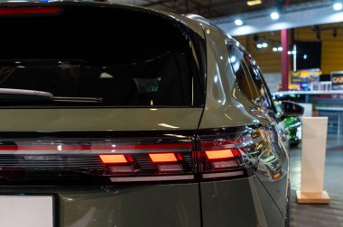 Riga, Letonya - 25 Nisan 2025: Parlak yeşil VW Touran kalabalık bir otomobil fuarında yenilikçi arka lambalarla kapalı mekanda sergilendi