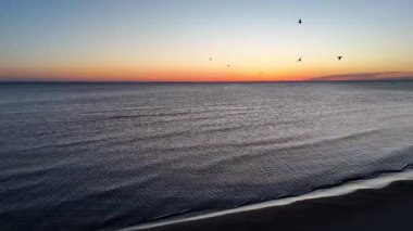 Güneşin doğuşunda sakin denizin üzerinde süzülen bir dron gibi sabahın dingin güzelliğini hissedin..