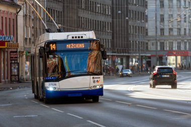 Riga, Letonya - 2 Mart 2021: Bir tramvay, binalar ve araçlarla dolu kalabalık bir caddede 14 hamle yaptı.