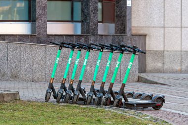 Riga, Letonya - 2 Mart 2021: Dış binanın yakınındaki beton bir patikada birkaç elektrikli scooter düzgün bir şekilde dizilmiş.