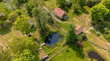 Ruhnu, Estonya - 1 Haziran 2025: Estonya 'da yemyeşil, göletler ve tatil kulübelerinin yer aldığı Ruhnu Adası manzarası.