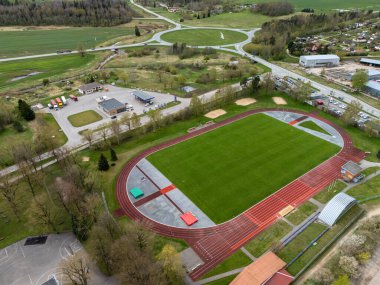 Tukums, Letonya - 26 Nisan 2025: Çevresindeki yeşil alanda geniş bir atletizm kompleksi kuruldu.