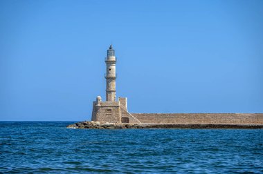 İkonik Chania deniz feneri Yunanistan 'ın Girit kentindeki derin mavi denize karşı dimdik ayakta duruyor.