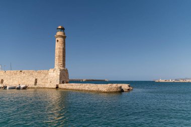 Deniz feneri, Girit, Rethymno 'daki açık mavi gökyüzünün altında limanın girişini gösteriyor..