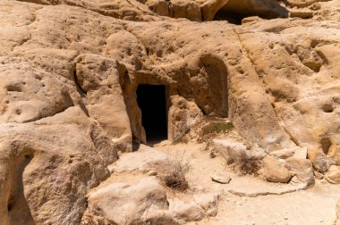 Ziyaretçiler güneşli bir öğleden sonra Matala, Girit 'teki eşsiz kaya oluşumlarını ve mağaraları keşfettiler.