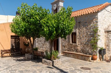 Krasi 'nin büyüleyici köy meydanını keşfedin. Çerçevelenmiş gür ağaçlar ve taş binalar..