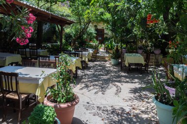 Yunanistan 'ın Girit kentinde gün boyunca ağaçların altındaki masalar yemek için davetkar bir ortam yaratıyor.