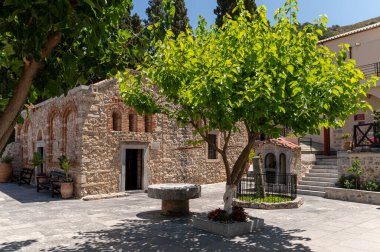 Girit, Yunanistan - 24 Haziran 2025: Ziyaretçiler Girit 'te doğa ile çevrili Kardiyotissas Manastırı' nın huzurlu atmosferinin keyfini çıkarıyorlar.