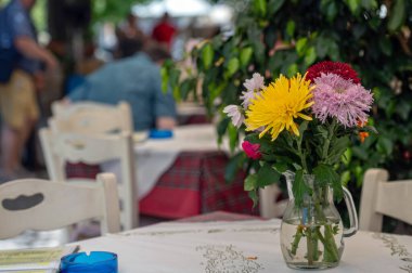 Parlak renkli çiçekler bir kafe masasını süslüyor, Girit 'te neşeli bir atmosfer yaratıyor..