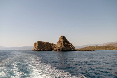 Ziyaretçiler Girit yakınlarındaki engebeli kaya oluşumları ve sakin suların güzel manzarasının keyfini çıkarıyorlar..