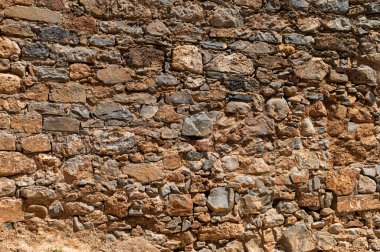 Eşsiz şekilleri ve dünyevi tonları vurgulayan desenli taş bir duvarın ayrıntılı görüntüsü.