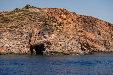 Ziyaretçiler Girit kıyı şeridinin eşsiz jeolojik özelliklerini parlak güneş ışığı altında takdir ediyorlar..