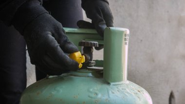 Basınç düzenleyicili bir LPG silindir bağlantısı. Gaz tüpünü bağlayan bir teknisyenin yakın çekimi. PVC borusu. Şişe mühürlendi ve kullanıma hazır.. 