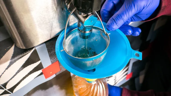 used frying oil. separation of oil from the fryer after being used. with funnel, plastic bottle and filter to retain food impurities.