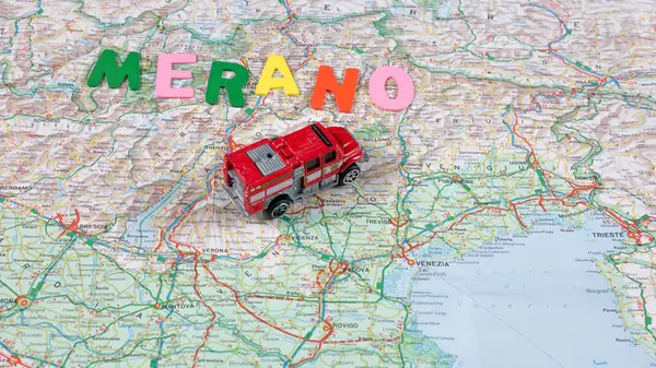 Italian paper travel geographical map with spinning toy car and the inscription holiday. High quality photo