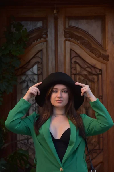 Красивая Молодая Женщина Шляпе Черном Пальто Позирует Фоне Деревянной Стены — стоковое фото