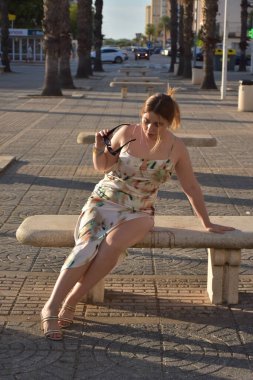 Şehir bankında giyinmiş genç bir kadın.