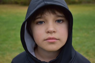 Başında başlığı olan küçük bir çocuk.