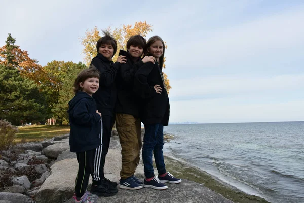 Tři Šťastní Mladí Chlapci Dívky Kráčející Břehu Podzimním Dni Royalty Free Stock Obrázky