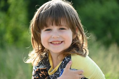 Çocuklar bir manzaranın arka planında oturuyorlar,