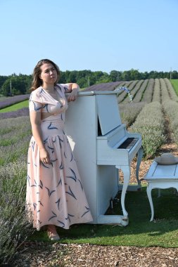 Lavanta tarlasında şapkalı kadın ve beyaz piyano