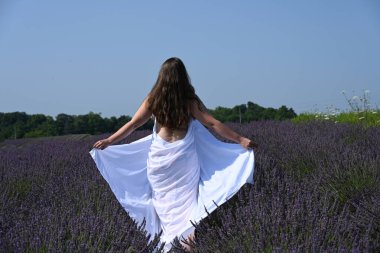 Lavanta tarlasında beyaz elbiseli bir kız.,