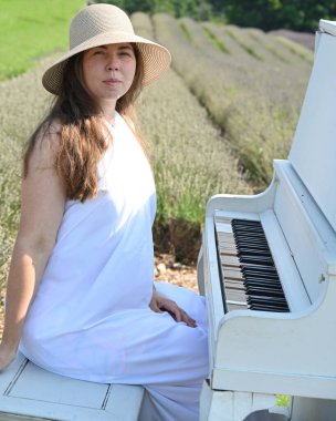 Lavanta tarlasında şapkalı kadın ve beyaz piyano