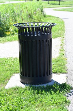 Bir manzaranın arka planında çöp kutuları,