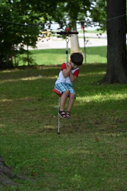 boy playing on the swing child riding on swing in park, clipart