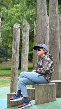 Parkta bankta oturan çocuk,