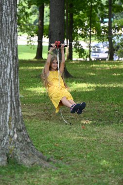 blonde girl riding a swing in the park, clipart