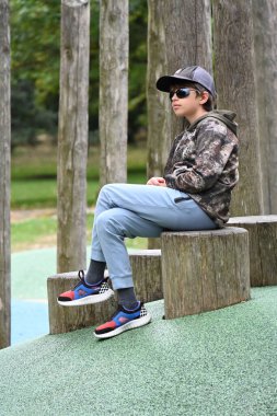 Parkta bankta oturan çocuk,