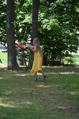 Parkta salıncakta sallanan sarışın kız.,