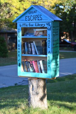 Ağaçta küçük bir ev, içinde kitaplar olan ücretsiz bir kütüphane.