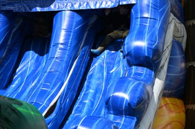 Çocuklar şişirilebilir trambolinde oynarlar.