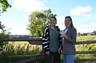 Parkta iki genç kadın manzaranın arka planında iki kadın.,