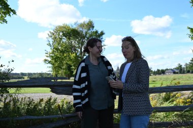 Parkta iki genç kadın manzaranın arka planında iki kadın.,